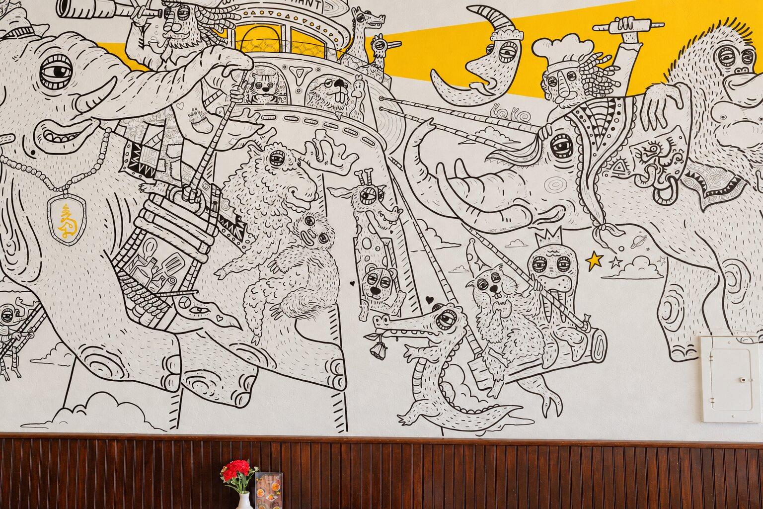 Detail of the mural: the elephant with a rider holding a spyglass, drawn in black line on white plaster.